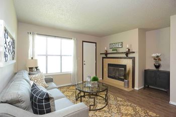 A living room with a grey couch and a fireplace.